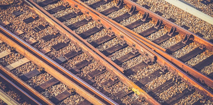 Rusty-hued closeup photograph of tracks running through a train yard